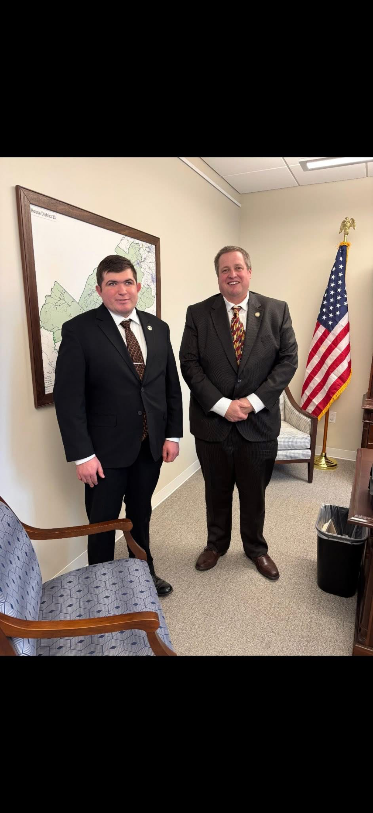 Lucas Cook meeting in an office with district and flag imagery in the background